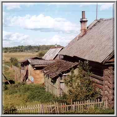 A wooden cabin north from Novgorod, view from a bus. Russia, August 1, 2001